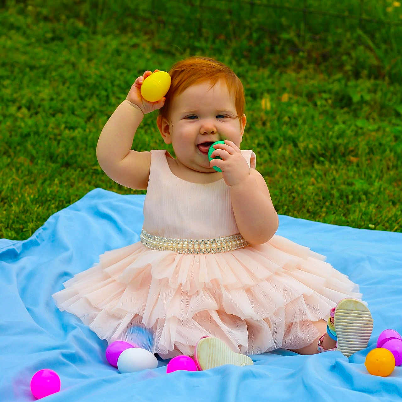 Sophia joined the competition — help win amazing prizes! baby, blue_blanket, celebration, child, colorful, cute, easter_eggs, fun, grass, happy, nature, outdoor, pink_dress, plastic_eggs, playful, portrait, sitting, smiling, toddler, young_child