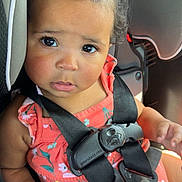 Lakyiah is registered to the contest to win money with this photo: toddler, child, car_seat, seatbelt, safety, coral_dress, floral, curly_hair, hair_tie, big_eyes, expression, hand, buckled_up, car_interior, black_straps, cute, innocent, portrait, young_child, baby