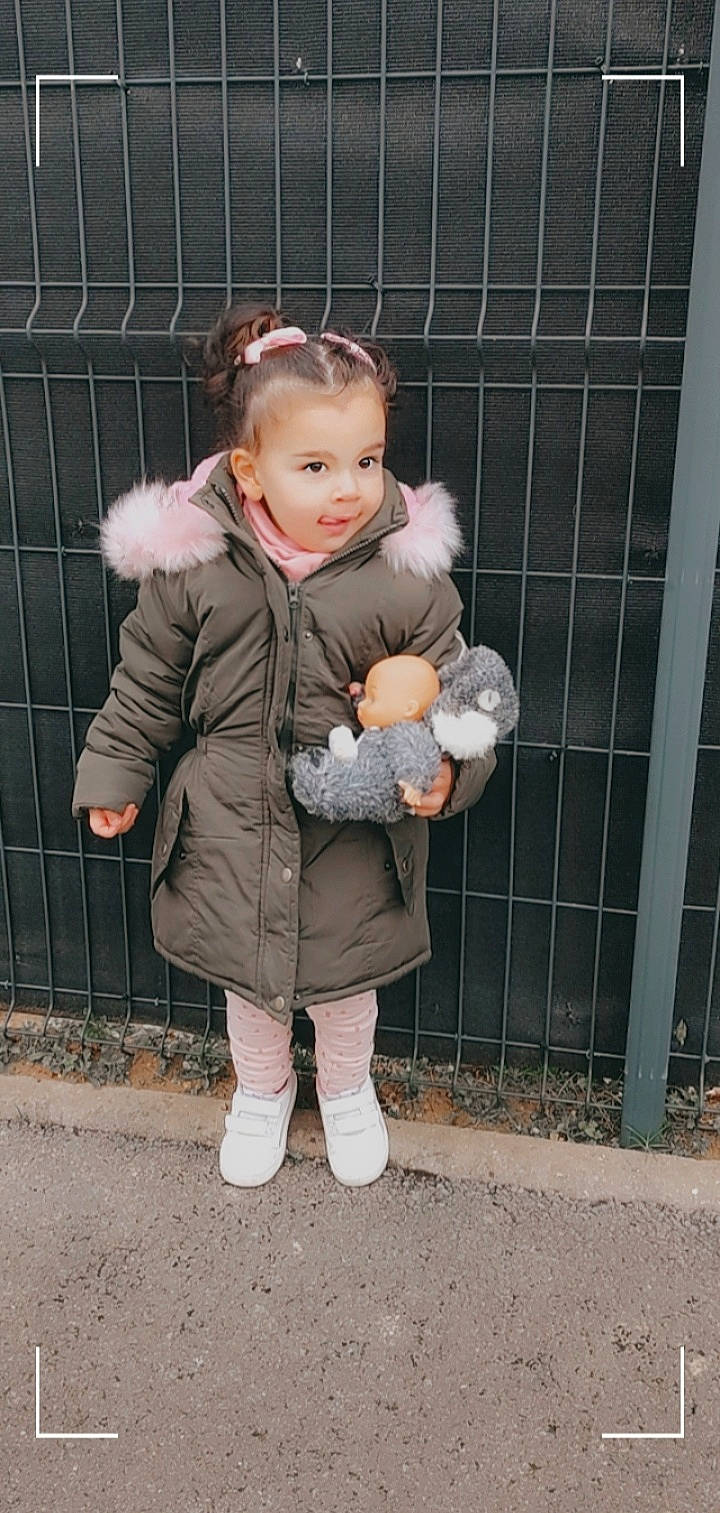 Chelsea participe au concours pour gagner de l'argent avec cette photo : arm, baby, baby_toddler_clothing, face, fawn, finger, fun, gesture, grass, hand, happy, jacket, outerwear, person, pink, skin, sleeve, smile, street_fashion, toddler