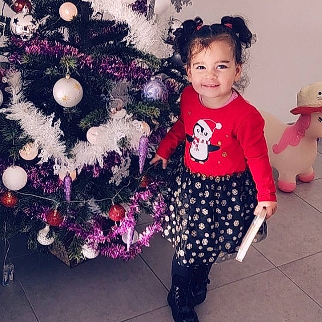 Chelsea a rejoint le concours — aidez-le/la à gagner de superbes lots ! baby_toddler_clothing, christmas_decoration, christmas_ornament, christmas_tree, cool, event, evergreen, fashion, happy, holiday, holiday_ornament, joy, magenta, mammal, ornament, person, pink, plant, sleeve, standing