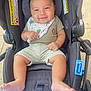 baby, smiling, stroller, bib, shorts, striped_clothing, infant, cute, child, foot, hand, seat, outdoor, warning_label, fabric, toy, comfort, playful, happy, portrait