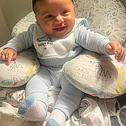Sigberto joined the competition — help win amazing prizes! baby, smiling, pajamas, bib, pillow, animal_print, blanket, indoor, child, happy, cute, infant, sitting, soft_lighting, cozy, face, footwear, pattern, fabric, portrait