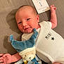 baby, newborn, onesie, plush_toy, milestone_card, soft_toy, infant, cute, smiling, lying_down, baby_clothes, blue, white, fabric, face, skin, hand, head, sleepy, child