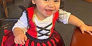 Serenity joined the competition — help win amazing prizes! toddler, child, smiling, dress, costume, pirate, red, black, indoor, wooden_furniture, chair, floor, happy, girl, person, hair, table, shoes, face, playful