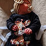 baby, infant, pacifier, headwear, bow, giraffe_print, clothing, black_outfit, hand, lying_down, soft_surface, fabric, cute, child, newborn, sleeping, indoors, warm_light, portrait, cozy