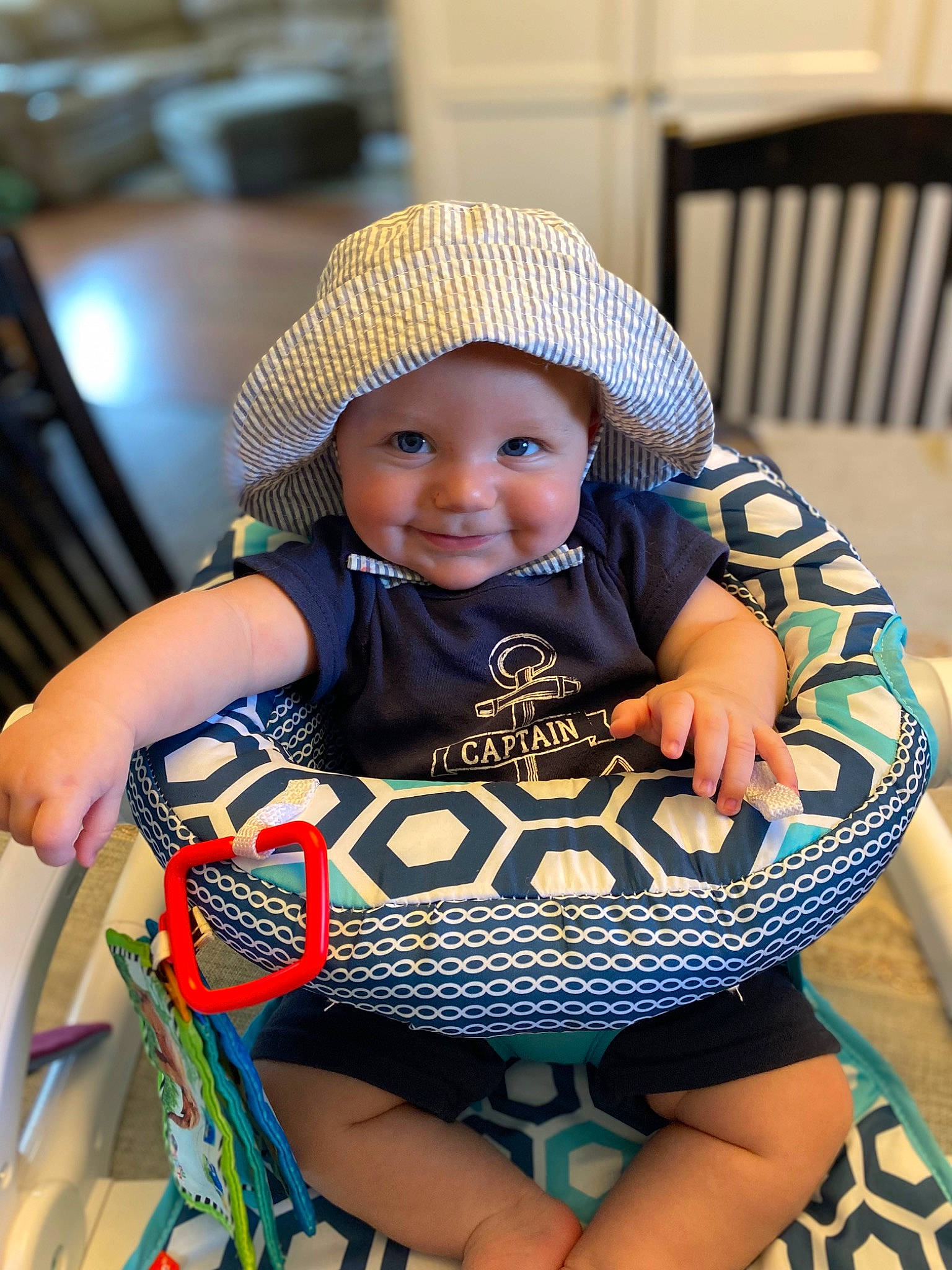 Jack is registered to the contest to win money with this photo: baby, baby_carriage, baby_products, baby_toddler_clothing, cap, chair, child, electric_blue, event, eye, facial_expression, fashion_accessory, fun, happy, headwear, joy, pattern, person, sitting, skin