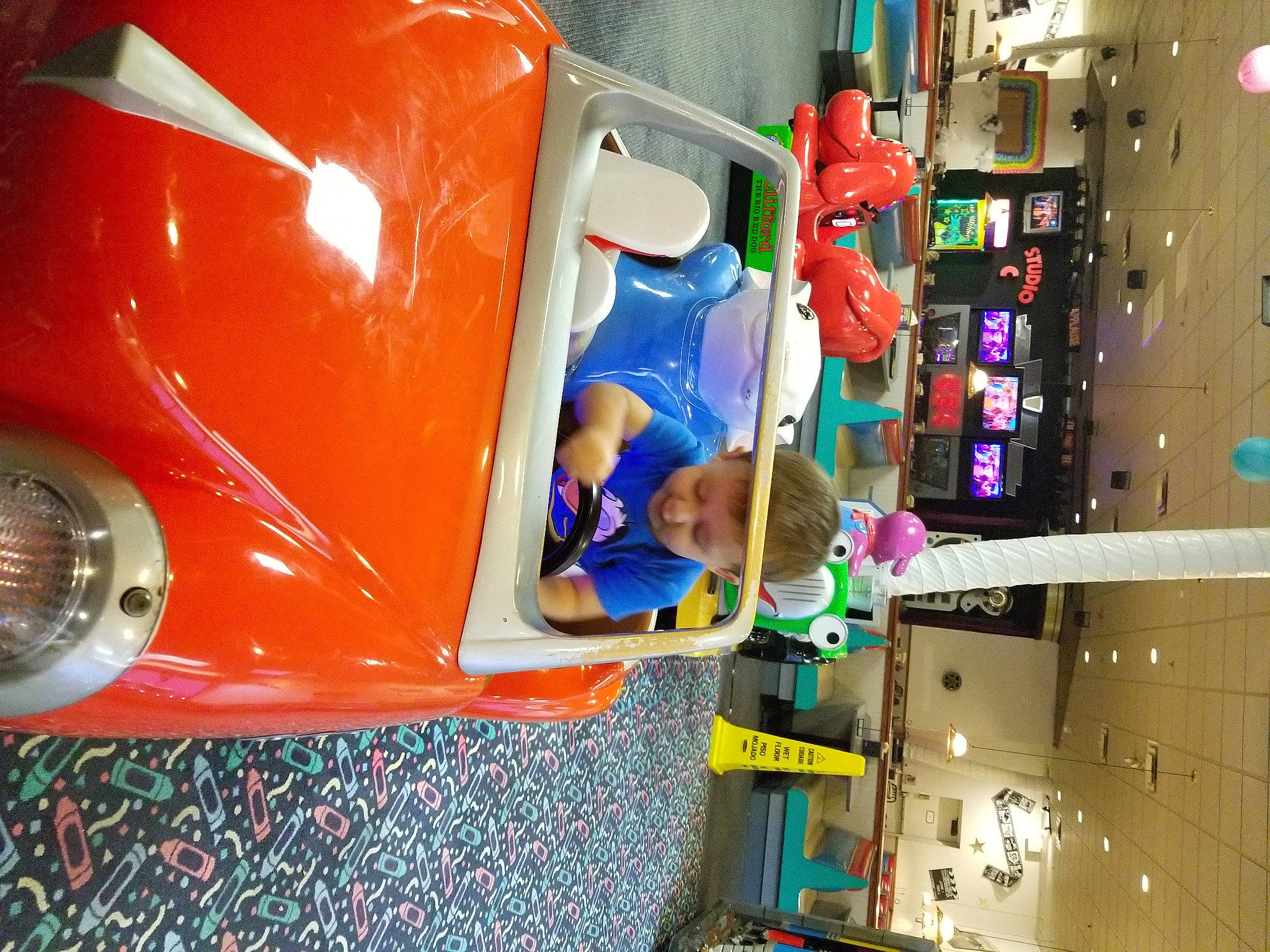 Isiah is registered to the contest to win money with this photo: automotive_design, automotive_exterior, automotive_lighting, bumper, child, classic_car, engineering, fun, games, headwear, leisure, machine, motor_vehicle, orange, person, play, recreation, retail, t_shirt, toddler