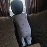 toddler, child, onesie, curly_hair, couch, cushion, window, curtains, indoors, cardboard_box, back_view, standing, soft_light, home, cozy, baby, fabric, furniture, looking_out, quiet