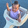 baby, chain, child, cute, daylight, expression, foot, hair_puffs, happy, outdoor, person, play, playground, purple_shirt, reaching, seat, smiling, swing, toddler, toy