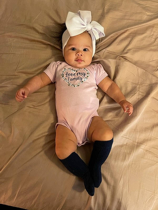 Aubriella is registered to the contest to win money with this photo: arm, baby, baby_toddler_clothing, child, comfort, face, finger, head, headgear, headwear, human_body, human_leg, knee, leg, person, skin, sleeve, stomach, t_shirt, textile