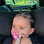 toddler, child, car_seat, pacifier, blanket, hair_ties, pony_tail, baby, portrait, seatbelt, indoor, car_interior, cute, soft_toy, closeup, curious, young_child, hand, face, expression
