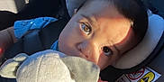 Isaiah joined the competition — help win amazing prizes! baby, car_seat, plush_toy, child, close_up, sunlight, shadow, seatbelt, cute, soft_toy, infant, portrait, hand, seat, headrest, expression, indoors, sitting, young_child, face