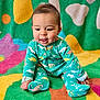 Isaiah joined the competition — help win amazing prizes! baby, child, onesie, dinosaur_pattern, colorful_blanket, sitting, happy, playful, indoor, portrait, cute, infant, smiling, bright_colors, soft_texture, young_child, face, hands, feet, clothing