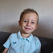 Ewan a rejoint le concours — aidez-le/la à gagner de superbes lots ! child, boy, smiling, polo_shirt, light_blue, sitting, couch, indoor, wall, short_hair, casual_clothing, portrait, happy, person, cute, young, comfortable, home, relaxed, face