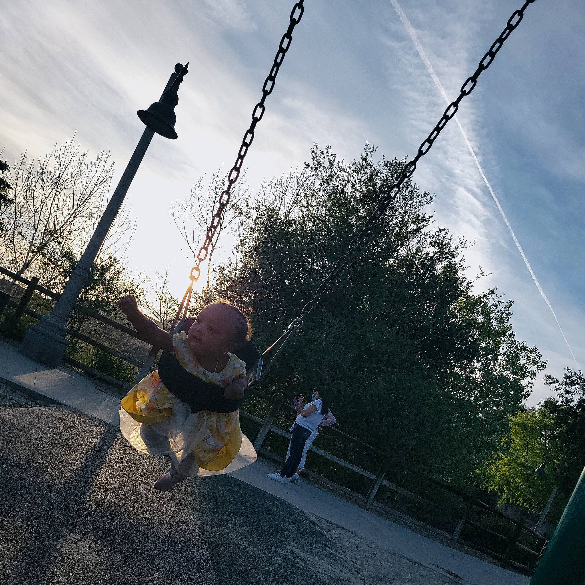 Jaziyah joined the competition — help win amazing prizes! asphalt, city, cloud, electricity, fun, happy, leisure, outdoor_play_equipment, overhead_power_line, person, playground, pole, recreation, road, rope, sky, street_stunts, stunt, swing, tree