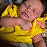 baby, sleeping, yellow_clothing, infant, closeup, peaceful, soft_lighting, face, arm, skin, cute, portrait, indoors, child, newborn, hand, fingers, relaxation, comfort, babywear