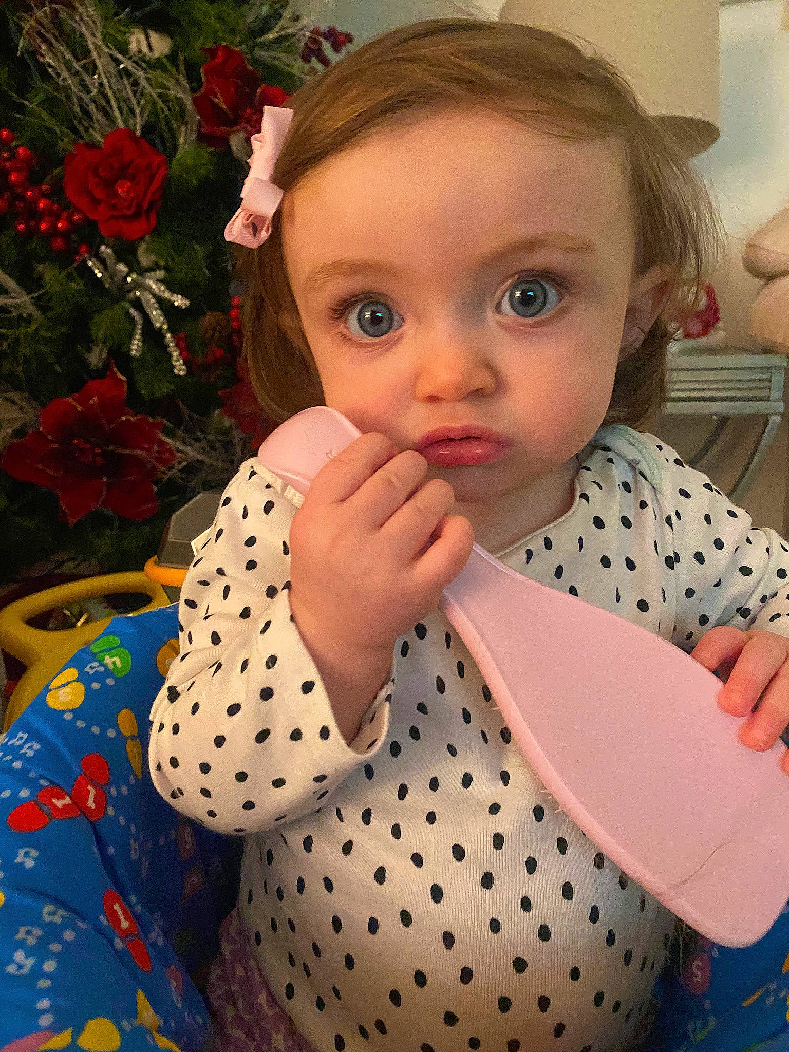 Arya is registered to the contest to win money with this photo: arm, baby_toddler_clothing, cheek, child, dress, eyelash, facial_expression, flower, hairstyle, happy, iris, lamp, lip, pattern, person, pink, plant, skin, sleeve, textile