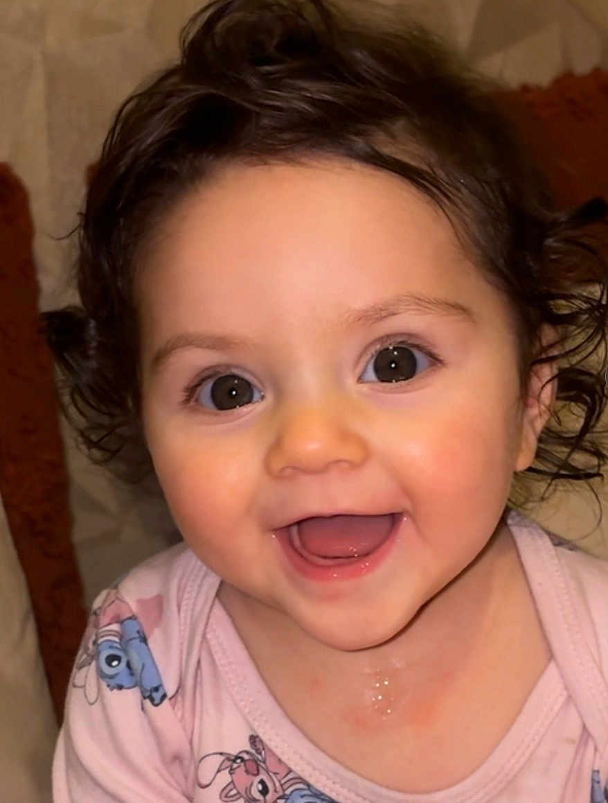 Kataleya participe au concours pour gagner de l'argent avec cette photo : baby, smiling, face, child, cute, pink_clothing, cartoon_print, curly_hair, happy, indoor, portrait, young_child, skin, big_eyes, mouth_open, cheeks, infant, joy, closeup, person