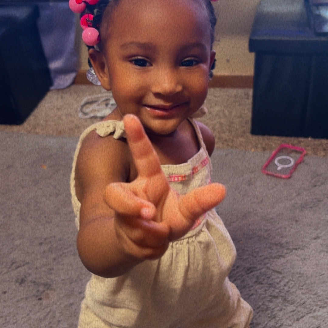 Harlee joined the competition — help win amazing prizes! carpet, child, clothing, cute, footwear, furniture, gesture, hair_beads, hand, happy, home, indoor, person, playful, portrait, room, smiling, television, toddler, young_child