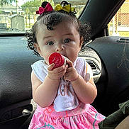 Ellie joined the competition — help win amazing prizes! baby, bottle_cap, car_interior, car_seat, child, clothing, curly_hair, cute, daylight, front_seat, hair_bows, hello_kitty, holding_object, infant, person, pink_dress, portrait, sitting, wide_eyes, window