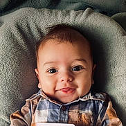 Evan a rejoint le concours — aidez-le/la à gagner de superbes lots ! baby, infant, smile, face, eyes, plaid_shirt, clothing, blanket, soft_texture, cute, child, portrait, happy, young, indoors, laying_down, closeup, head, cheeks, skin