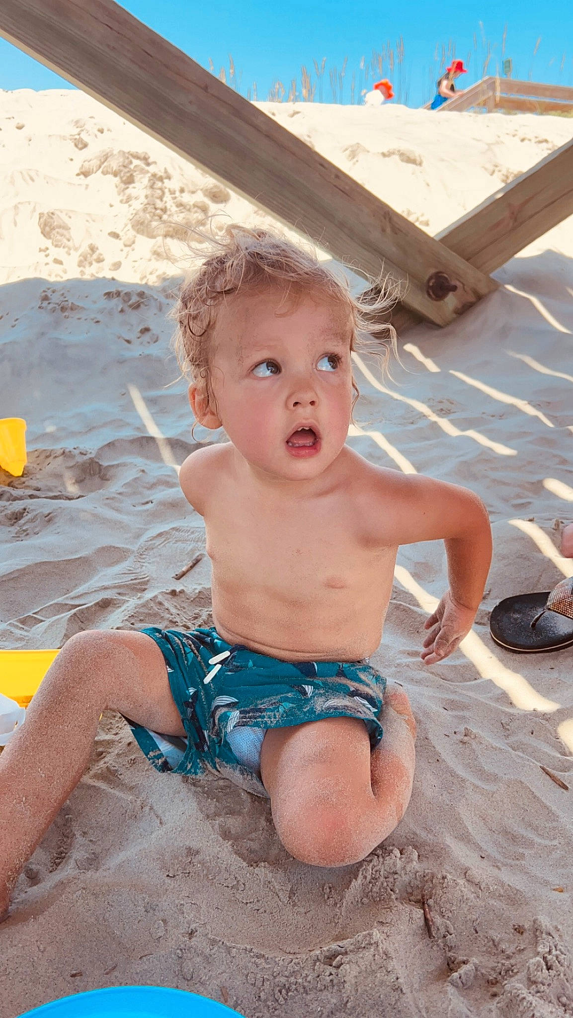 Aiden joined the competition — help win amazing prizes! abdomen, baby, barechested, blue, body_of_water, chest, child, fun, human_leg, leisure, person, recreation, sand, sitting, summer, sunglasses, surprise, swimwear, thigh, toddler