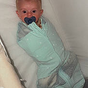 Max is registered to the contest to win money with this photo: baby, pacifier, sleep_sack, crib, infant, bed, blanket, mesh, star_pattern, clothing, child, comfort, resting, cute, young, indoor, portrait, sleeping_bag, newborn, lying_down