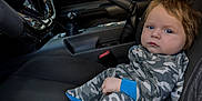 Ryder is registered to the contest to win money with this photo: baby, blue_eyes, camouflage, car_interior, child, clothing, dashboard, gear_shift, hair, hand, leather, mustang, portrait, seat, seatbelt, side_mirror, steering_wheel, tree, window, young_child