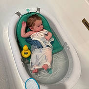 Ryder is registered to the contest to win money with this photo: baby, bathtub, bath, towel, water, rubber_duck, thermometer, infant, bath_seat, skin, wet_hair, white, blue, bathroom, relaxing, child, small, cute, toy, clean