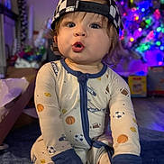 Ryder is registered to the contest to win money with this photo: baby, cap, carpet, checkered, child, christmas_tree, colorful_lights, cozy, cute, festive, foot, hand, holiday, indoor, infant, onesie, portrait, sitting, sports_theme, surprised_expression