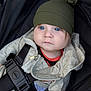 baby, child, stroller, hat, blue_eyes, jacket, zipper, straps, clothing, infant, person, portrait, cute, casual_wear, seatbelt, sitting, young, face, headwear, outdoor