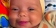 Kinlee is registered to the contest to win money with this photo: baby, smiling, bow, headband, infant, tongue, cute, colorful, blanket, cartoon, clothing, closeup, face, child, happy, portrait, indoors, soft, adorable, playful