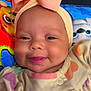 baby, smiling, bow, headband, infant, tongue, cute, colorful, blanket, cartoon, clothing, closeup, face, child, happy, portrait, indoors, soft, adorable, playful