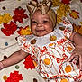 baby, smiling, headband, bow, dress, pumpkin, autumn, leaves, blanket, pattern, child, cute, happy, infant, face, portrait, clothing, lying_down, indoor, celebration