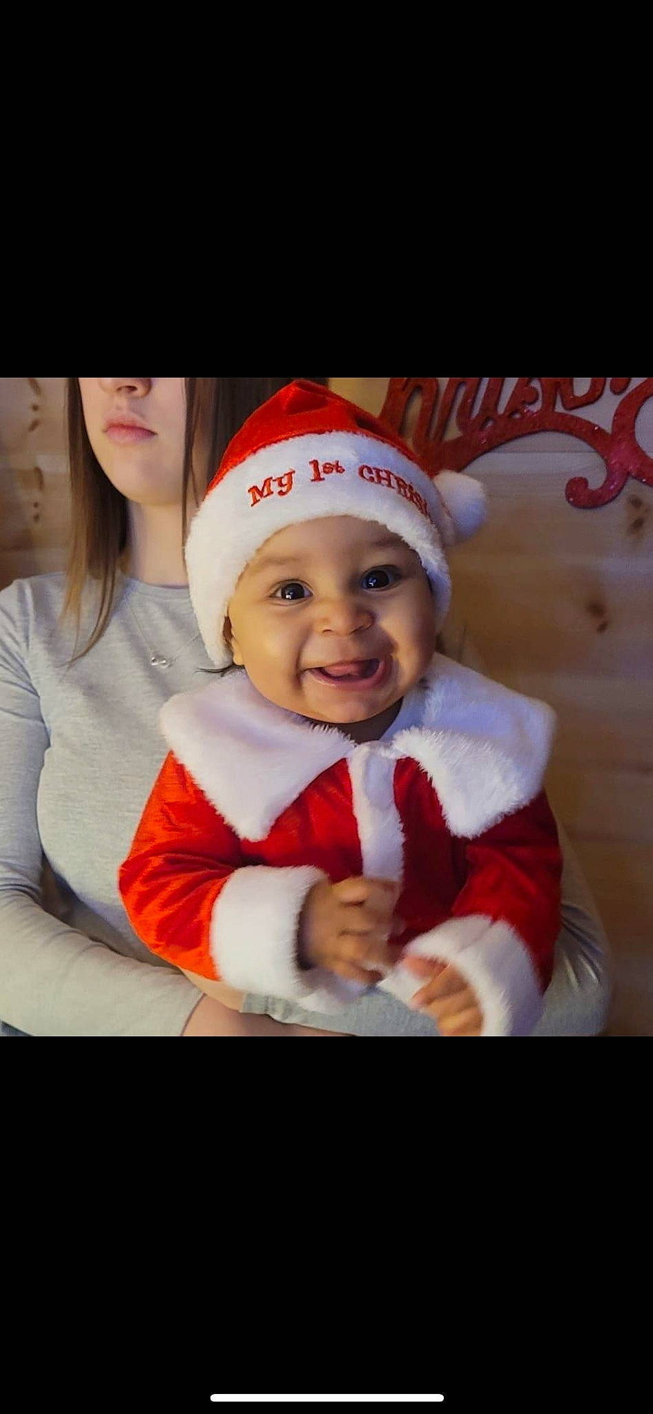 Kiyah is registered to the contest to win money with this photo: baby, cap, child, christmas, christmas_eve, event, face, fictional_character, fun, happy, holiday, human_body, lap, laugh, person, santa_claus, sleeve, smile, toddler, tree