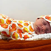 Rory joined the competition — help win amazing prizes! baby, sleeping, newborn, pumpkin_pattern, hat, blanket, soft_texture, cozy, infant, cute, face, closed_eyes, rest, warm_colors, autumn_theme, clothing, comfort, portrait, indoors, peaceful