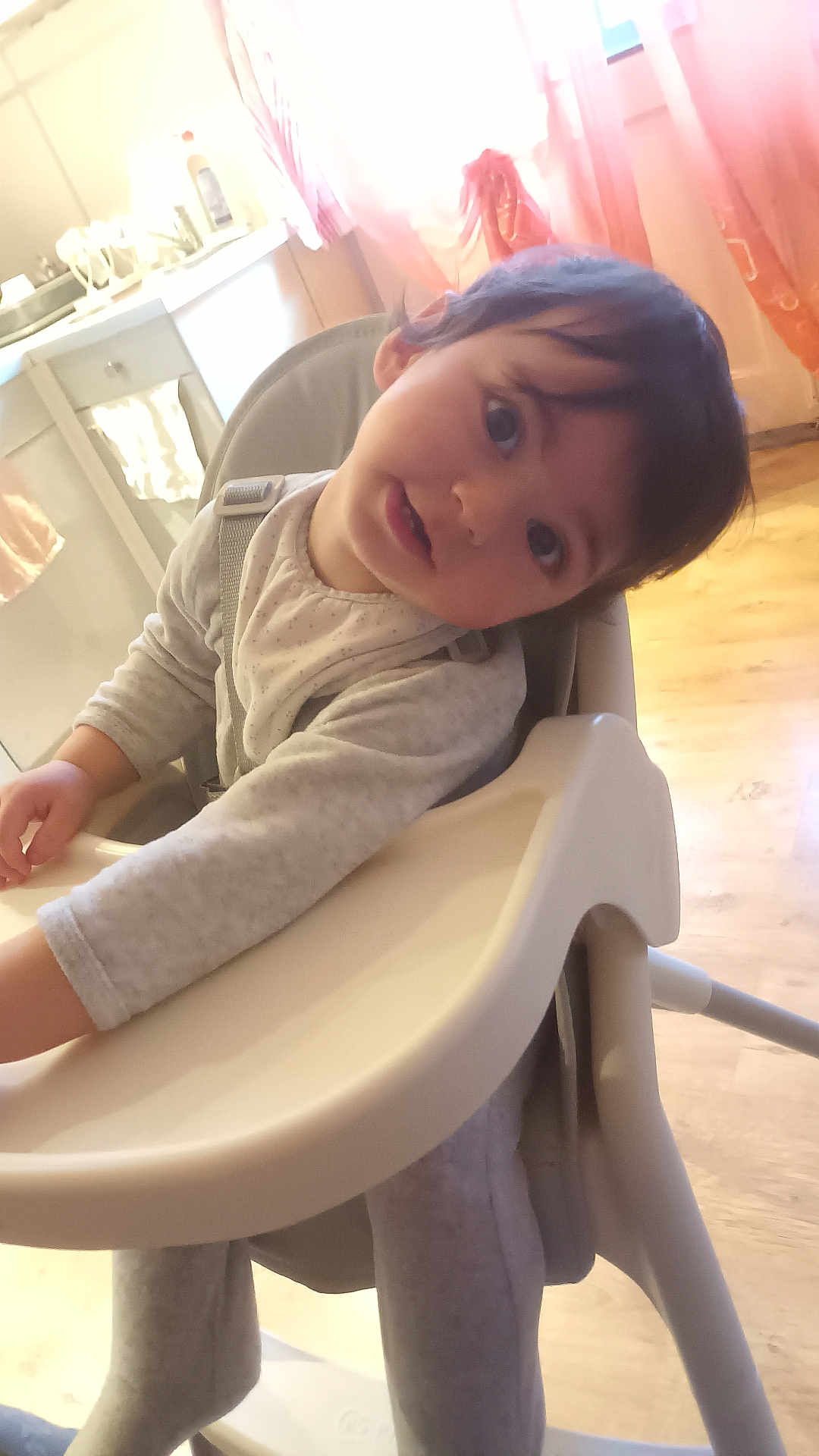 Eray a rejoint le concours — aidez-le/la à gagner de superbes lots ! toddler, child, high_chair, face, curious, indoor, kitchen, window, curtains, light, baby_clothes, seat, wooden_floor, cabinet, expression, person, young_child, home, infant, portrait
