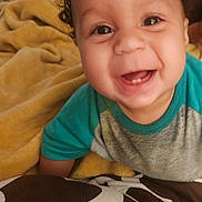Joel joined the competition — help win amazing prizes! baby, smiling, curly_hair, blanket, indoor, happy, face, child, cute, portrait, clothing, toddler, cozy, infant, home, person, young_child, expression, warm, cheerful