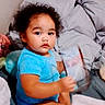 Miah'Ja joined the competition — help win amazing prizes! bed, blanket, blue_shirt, casual, child, cozy, curly_hair, cute, holding, home, indoor, looking_at_camera, person, plastic_container, portrait, relaxed, sitting, toddler, young, young_child