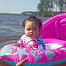 Miah'Ja joined the competition — help win amazing prizes! toddler, child, inflatable_ring, water, lake, summer, outdoor, hand, curly_hair, serious_face, swimwear, pink, blue, nature, trees, sunlight, baby, floating, play, recreation