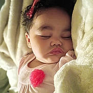 Miah'Ja is registered to the contest to win money with this photo: baby, sleeping, blanket, curly_hair, pink_bow, face, child, soft, cozy, infant, closeup, resting, peaceful, cute, indoors, portrait, apparel, flesh_tone, head, toddler