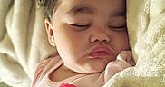 Miah'Ja is registered to the contest to win money with this photo: baby, sleeping, blanket, curly_hair, pink_bow, face, child, soft, cozy, infant, closeup, resting, peaceful, cute, indoors, portrait, apparel, flesh_tone, head, toddler