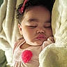 baby, sleeping, blanket, curly_hair, pink_bow, face, child, soft, cozy, infant, closeup, resting, peaceful, cute, indoors, portrait, apparel, flesh_tone, head, toddler