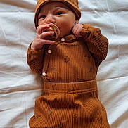 Joshua a rejoint le concours — aidez-le/la à gagner de superbes lots ! baby, infant, pacifier, hat, brown_outfit, croissant_pattern, knitted_socks, white_blanket, lying_down, cute, cozy, sleepwear, child, newborn, soft_texture, warm_clothing, indoors, portrait, adorable, resting