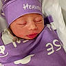 newborn, baby, sleeping, wrapped, purple_blanket, hat, hospital, bassinet, pacifier, infant, cute, peaceful, face, clothing, indoors, resting, child, soft, tiny, portrait