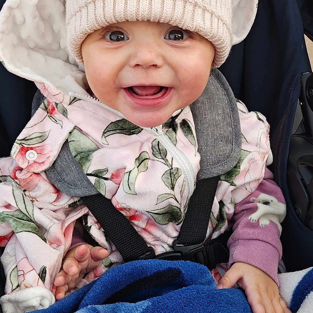 Nylah is registered to the contest to win money with this photo: baby, beanie, blanket, bundle, child, cozy, cute, face, floral_pattern, hands, happy, hat, hood, infant, jacket, outside, person, smiling, stroller, warm_clothing