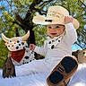 Jaysel is registered to the contest to win money with this photo: baby, child, cowboy, cowboy_hat, longhorn_toy, plush_toy, outdoor, tree, sunlight, portrait, smiling, sitting, white_outfit, bandana, boots, fluffy_blanket, western_theme, animal_toy, playful, ranch_style