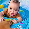 baby, infant, child, smiling, happy, portrait, face, eyes, open_mouth, short_hair, brown_shirt, blue_playmat, activity_center, toy, colorful, indoor, close_up, adult_hand, playtime, family