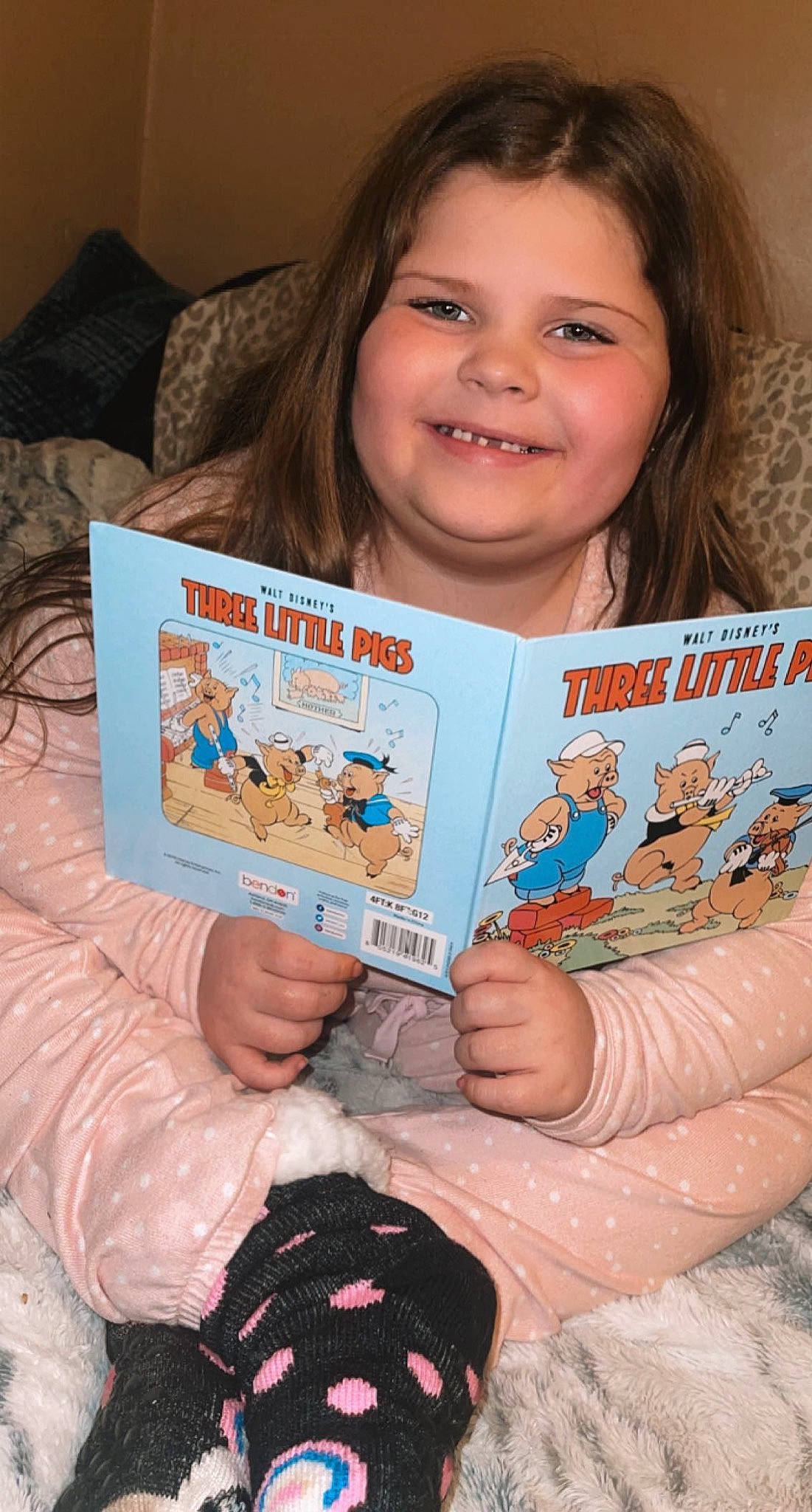 Gracelynn is registered to the contest to win money with this photo: book, child, eyelash, facial_expression, finger, fun, hand, happy, iris, joy, nail, organ, people, person, pink, play, publication, reading, room, smile