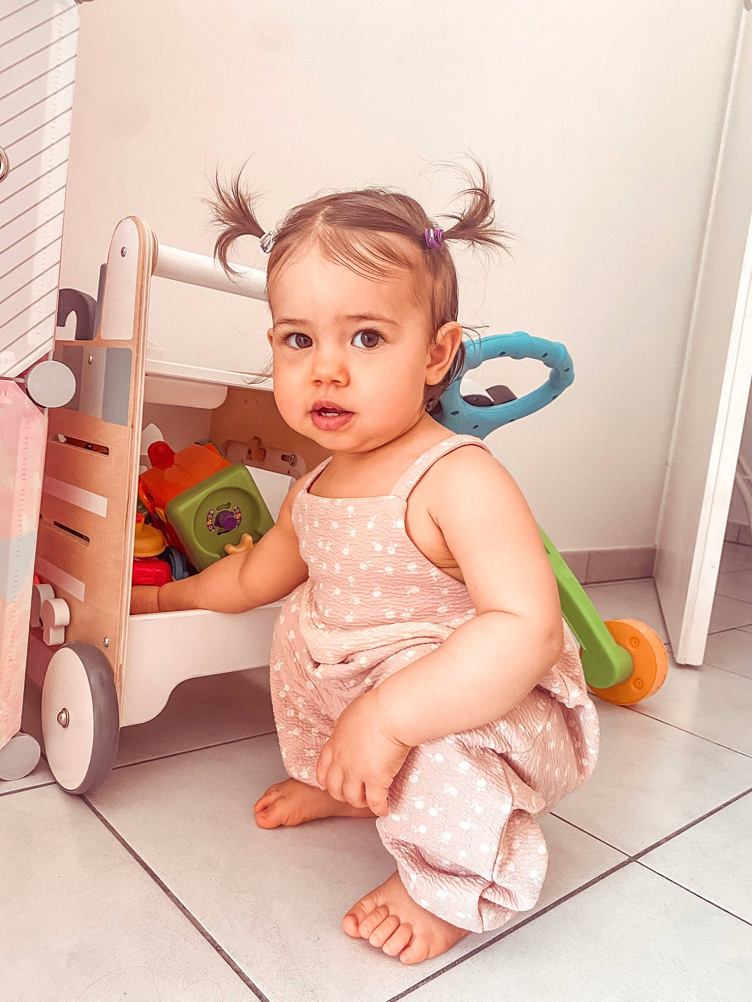 Elaïa a rejoint le concours — aidez-le/la à gagner de superbes lots ! baby, baby_toddler_clothing, barefoot, cheek, child, floor, flooring, foot, happy, hardwood, human_leg, leg, person, pink, product, sitting, skin, sleeve, toddler, wheel